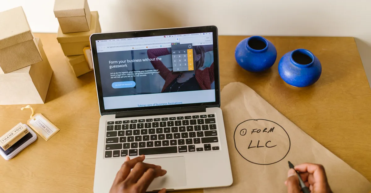 A small business workspace with a laptop, shipping boxes and handwritten planning notes.