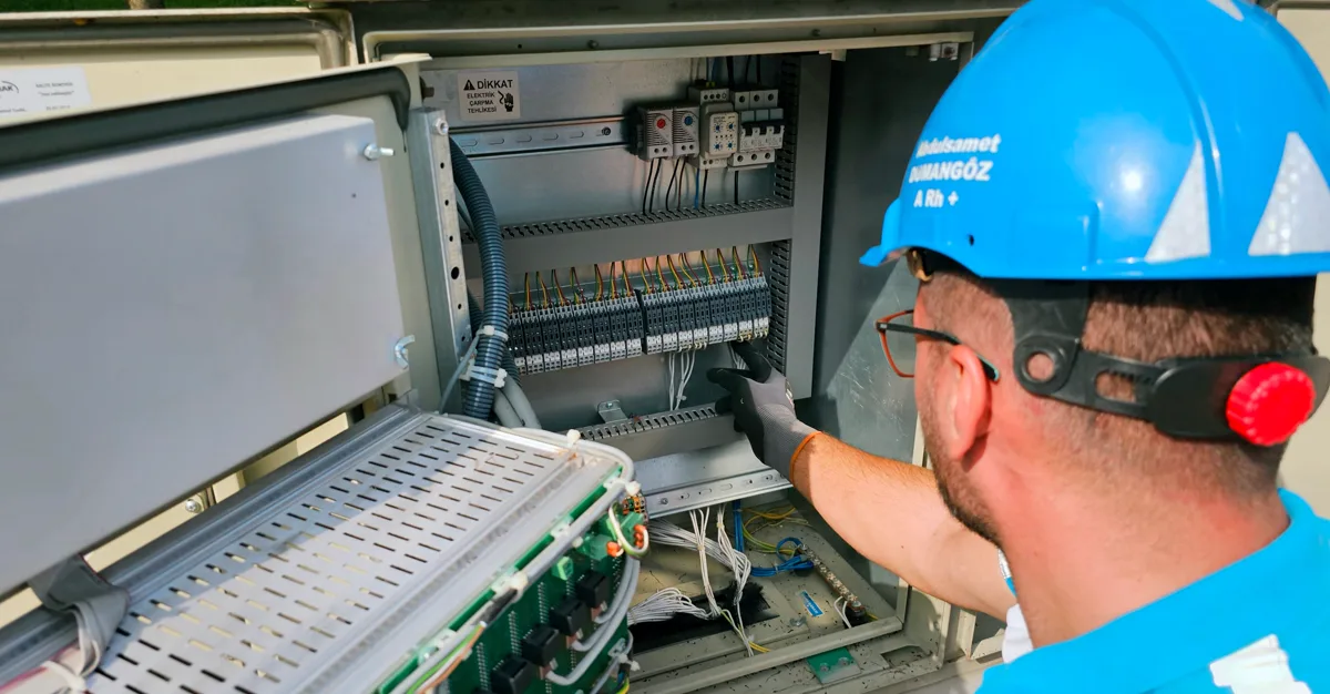 An electrician working on an outdoor fusebox.