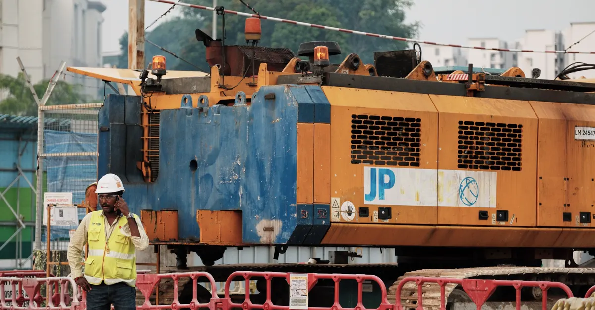 A worker taking a phone call on a construction site, representing contractor lead generation.